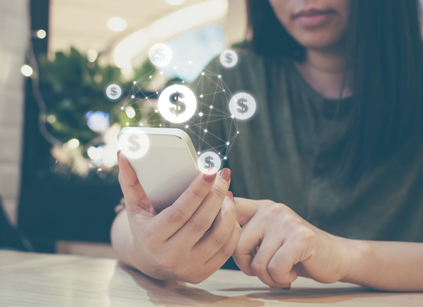Person holding a smartphone with dollar sign graphics overlaid