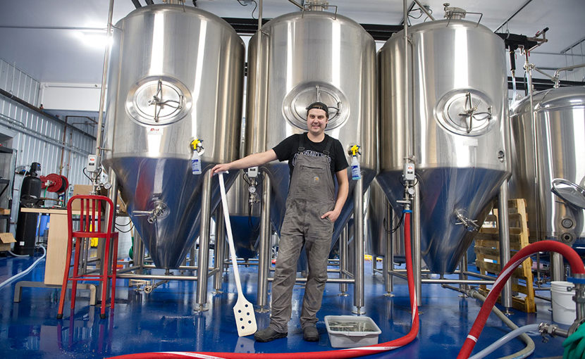 Entrepreneur in a brewer standing in front of fermenters