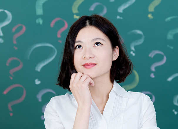 Person looking up with chin in hand in front of a background of question marks