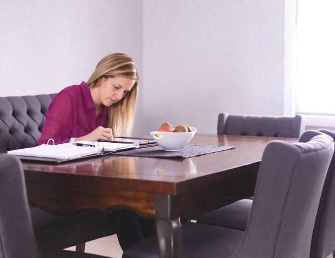 Job seeker at a dining table with tablet and binder