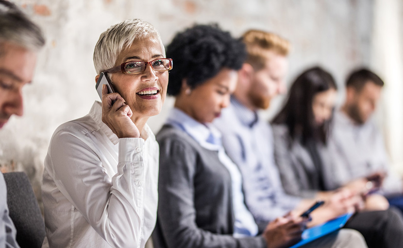 Person waiting in interview lineup talking on a smartphone