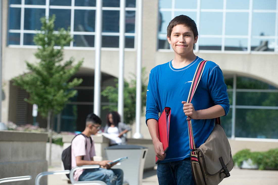 Youth student standing outside campus building