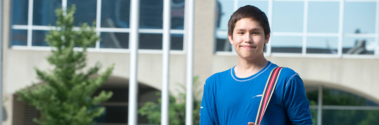 Youth student standing outside campus building