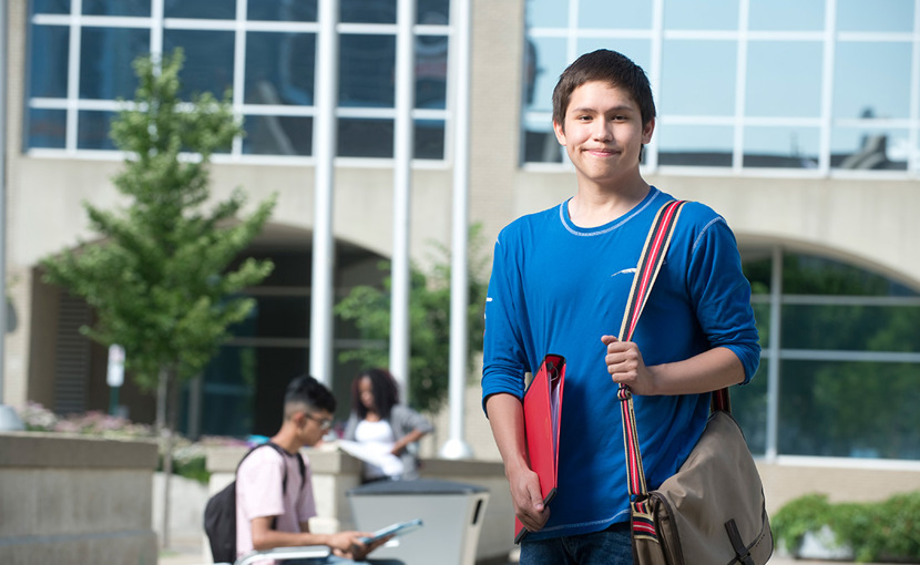 Youth student standing outside campus building