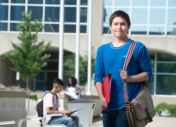 Youth student standing outside campus building