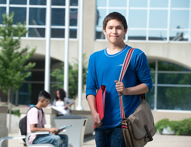 Youth student standing outside campus building