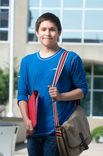 Youth student standing outside campus building