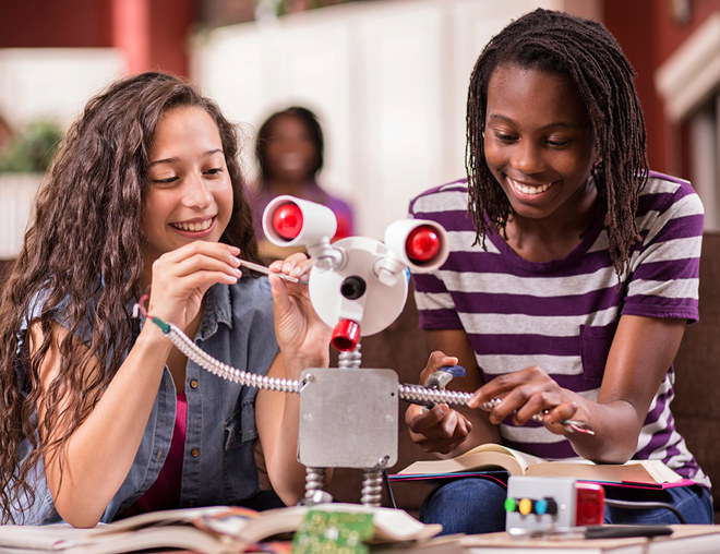 High school students building a robot in a classroom