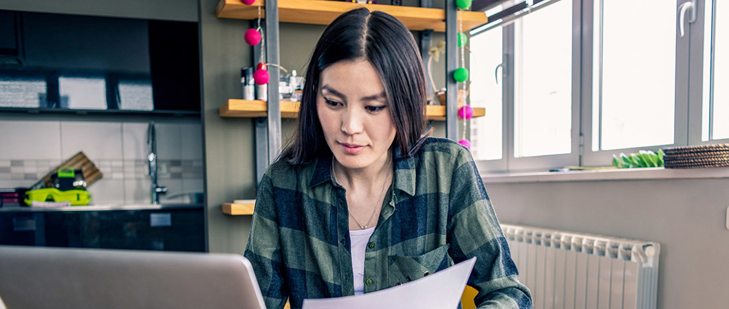 Person working at home with laptop and paper