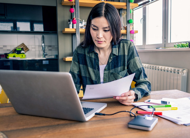 Person working at home with laptop and paper