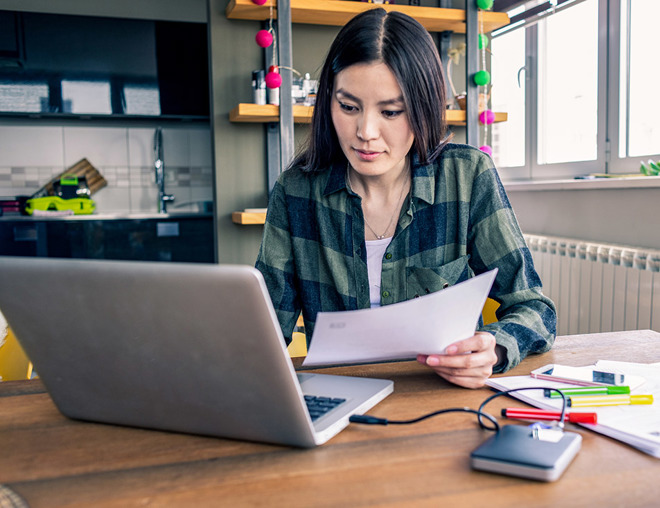 Person working at home with laptop and paper