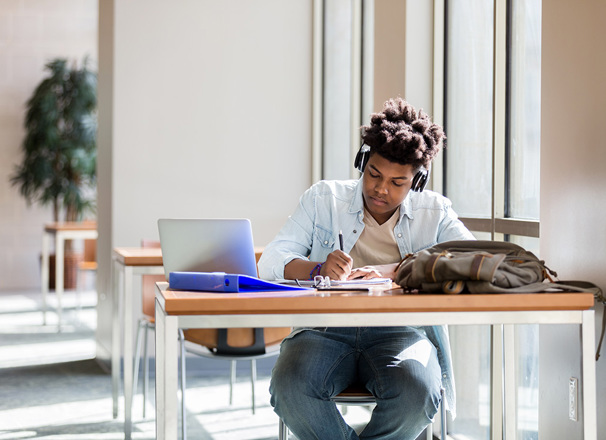 Person studying at a desk wearing headphones