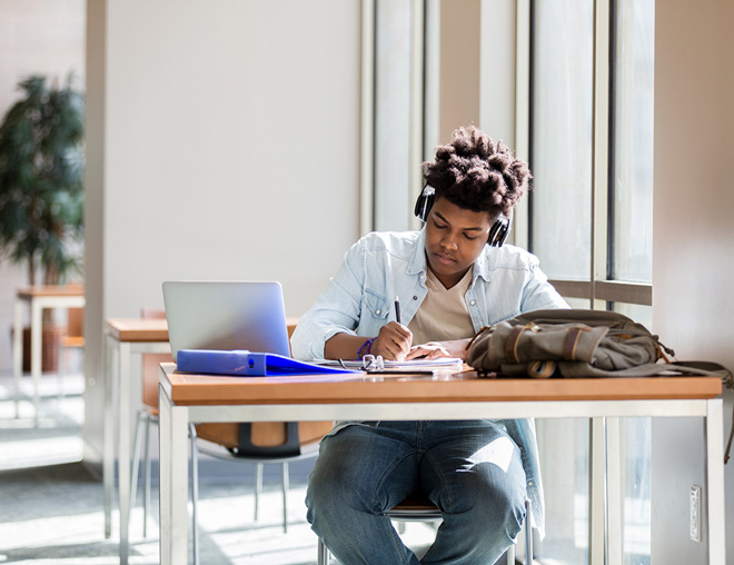 Person studying at a desk wearing headphones