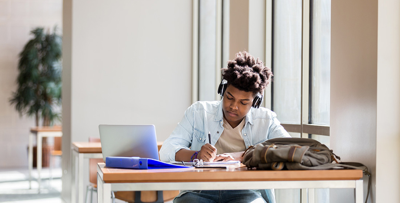 Person studying at a desk wearing headphones