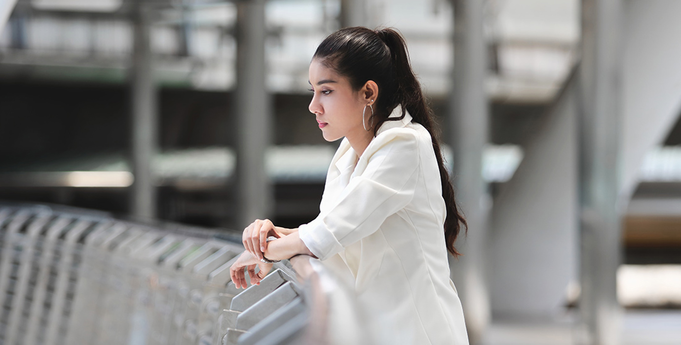Person thinking and leaning against a railing