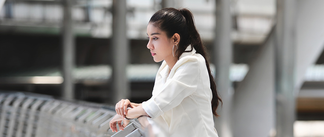 Person thinking and leaning against a railing