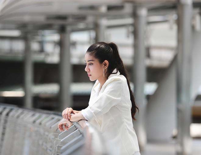 Person thinking and leaning against a railing