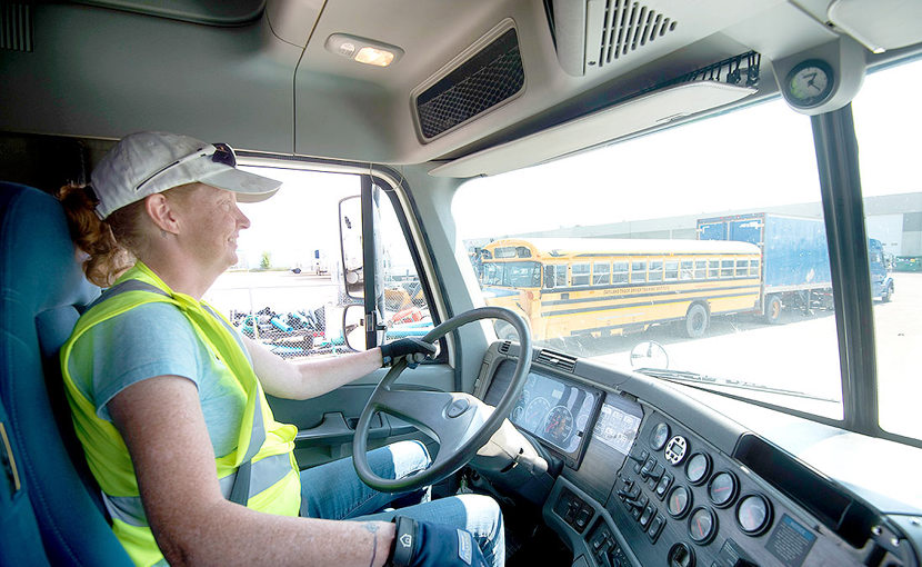Truck driver wearing a safety vest driving a truck