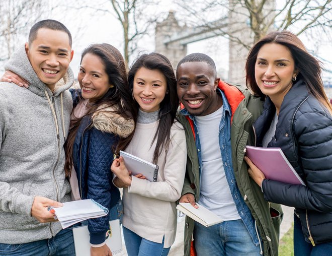 Post-secondary students standing in London with Tower Bridge in the background