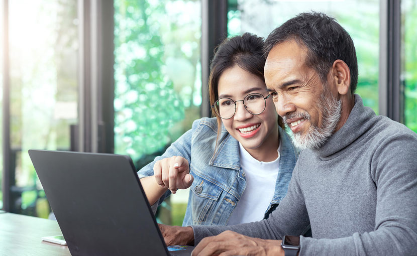 Youth and adult looking at a laptop together