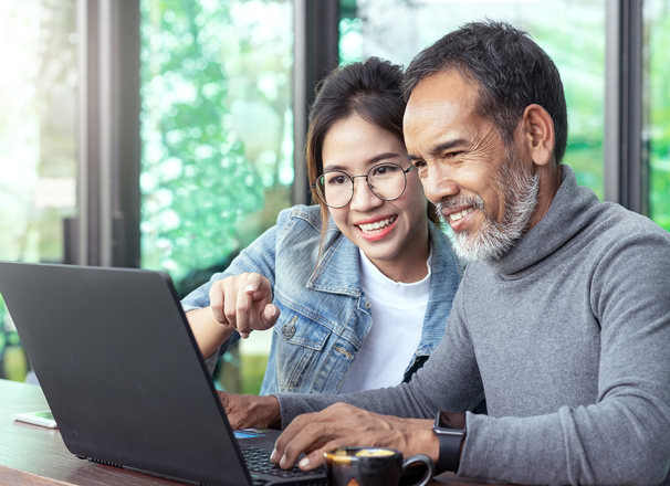 Youth and adult looking at a laptop together