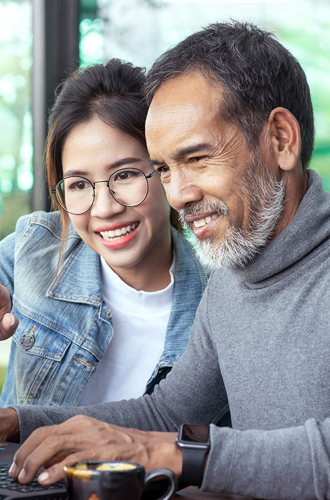 Youth and adult looking at a laptop together