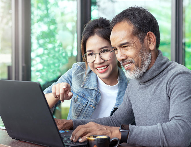 Youth and adult looking at a laptop together