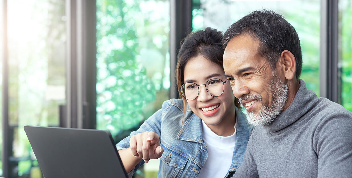 Youth and adult looking at a laptop together