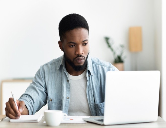 Person taking notes for a resume with pen and paper