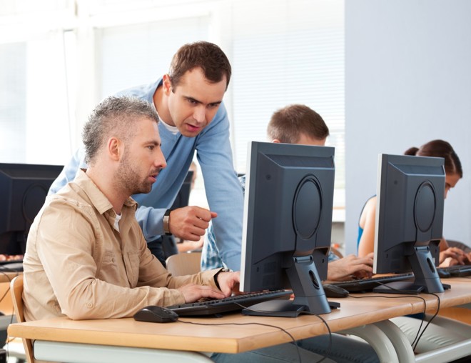 Mature student and teacher talking in a computer lab