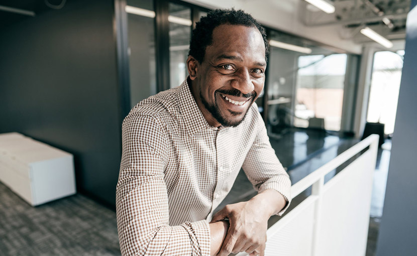 Person smiling into the camera leaning on a balcony railing