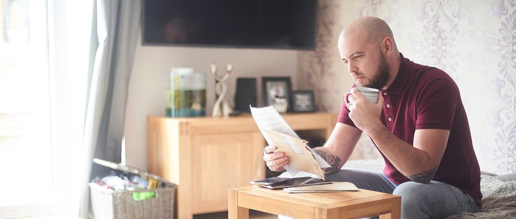 Person reviewing paperwork while sitting in the living room
