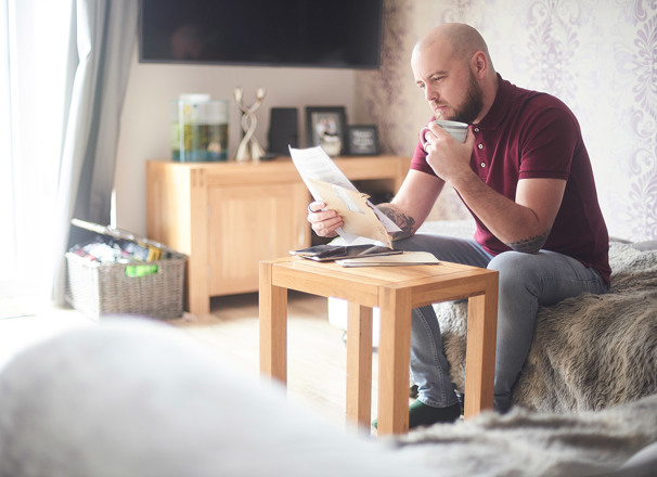Person reviewing paperwork while sitting in the living room