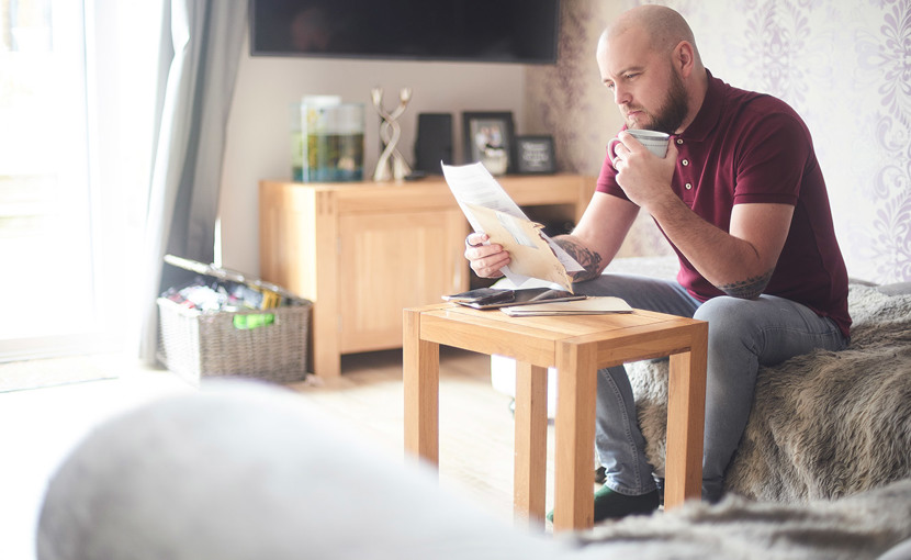Person reviewing paperwork while sitting in the living room