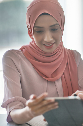 People in business casual attire looking at a tablet