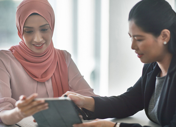People in business casual attire looking at a tablet