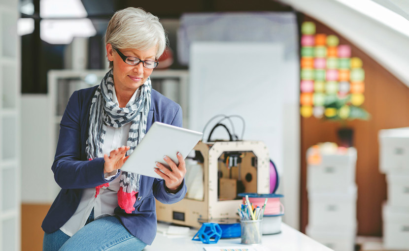 Person sitting on a desk looking at a table in an office