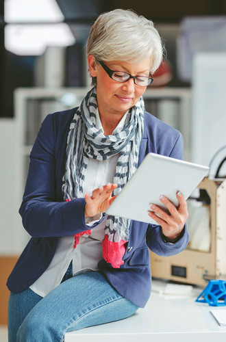 Person sitting on a desk looking at a table in an office