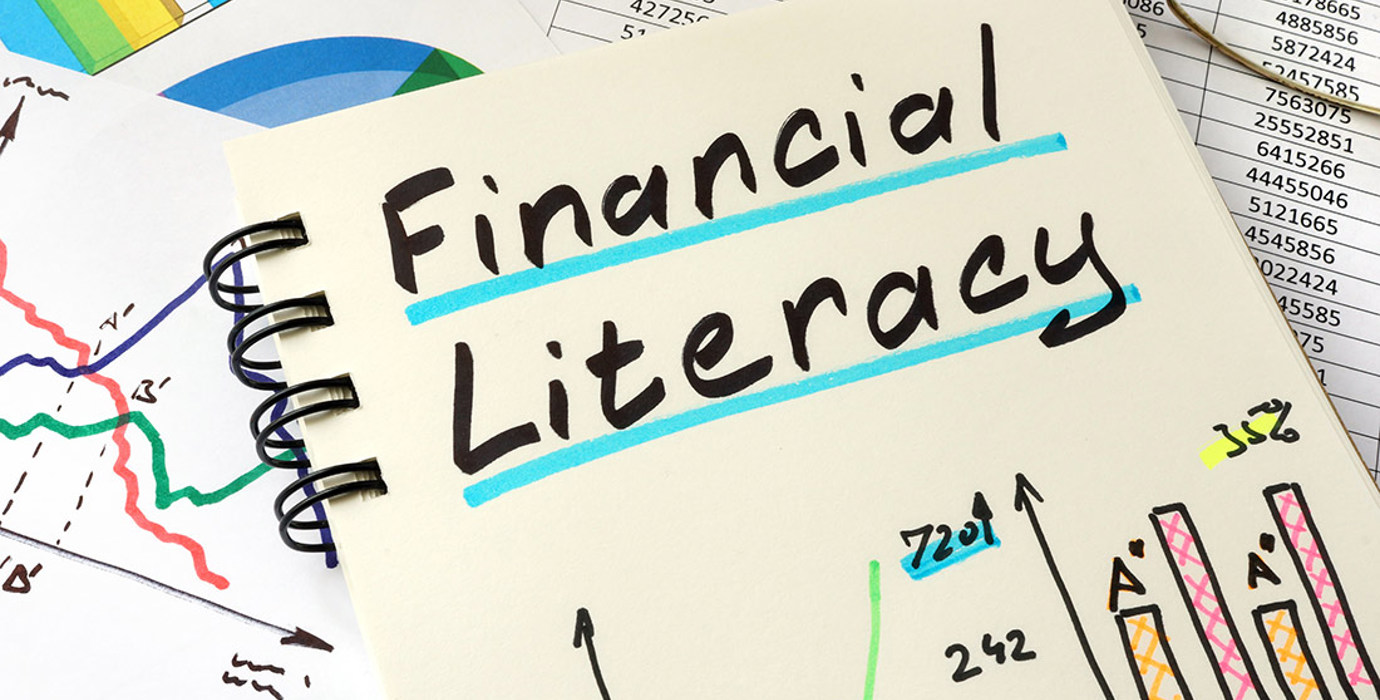 Notebook with colourful graphs with handwritten title "Financial Literacy"