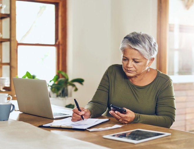 Person taking notes at a kitchen counter