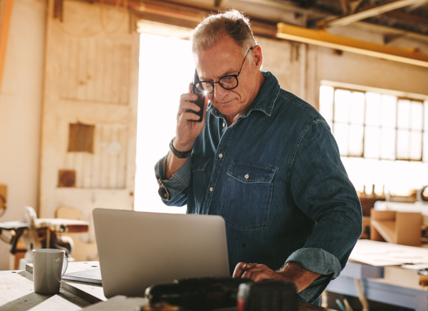 Carpenter on the phone in a workshop