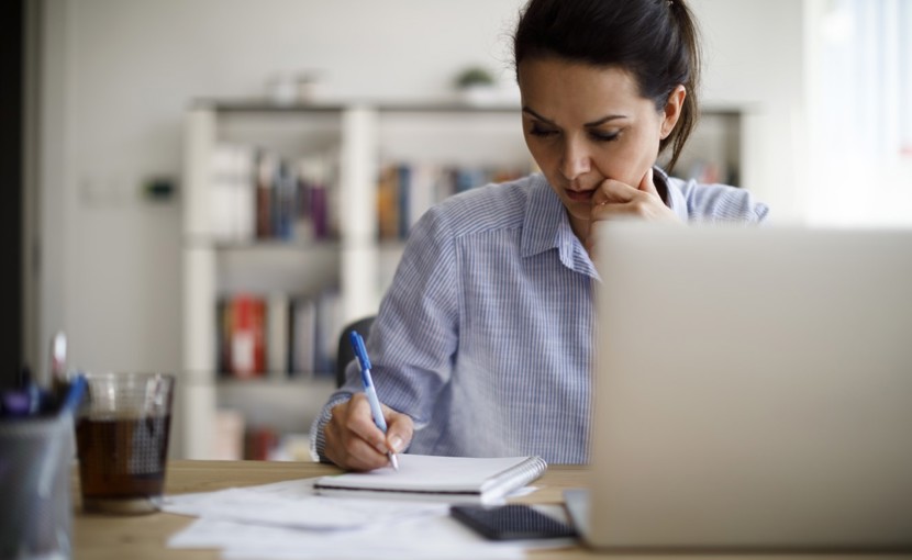 Person writing in a notebook at a desk