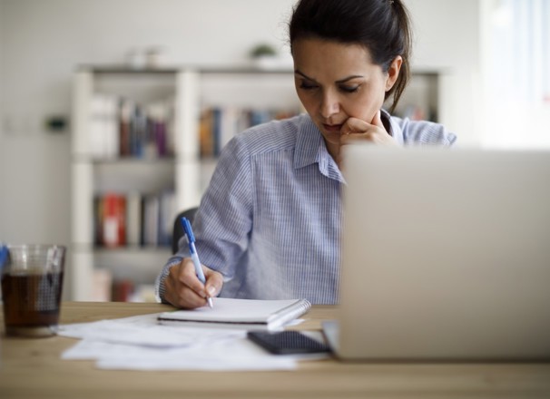 Person writing in a notebook at a desk