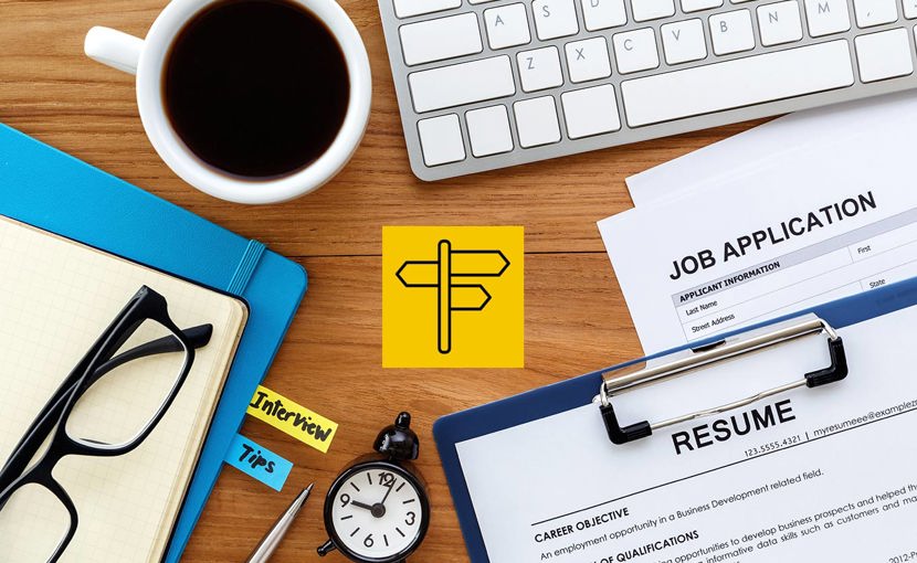 Resume, job application, notebooks, keyboard, coffee and a clock laid out on a desk