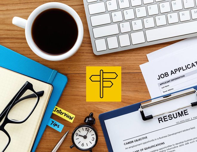 Resume, job application, notebooks, keyboard, coffee and a clock laid out on a desk