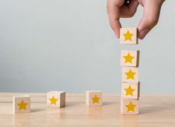 A hand stacking wooden blocks with yellow blocks on top of each other