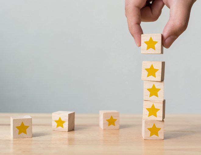 A hand stacking wooden blocks with yellow blocks on top of each other