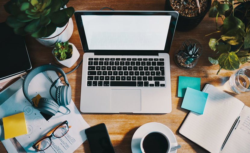 Open laptop with blank screen and other office supplies on a work desk