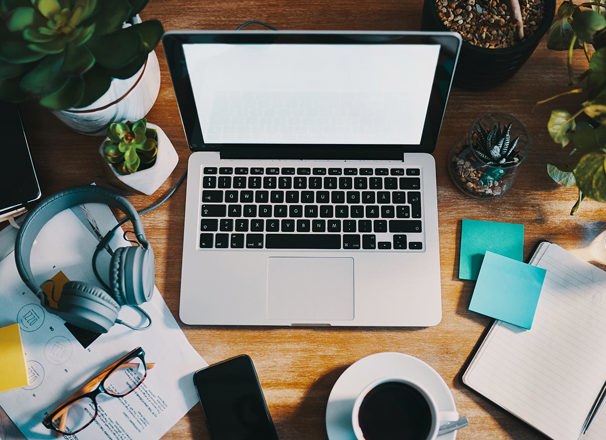 Open laptop with blank screen and other office supplies on a work desk