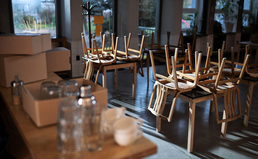 Closed restaurant with chairs overturned on tables